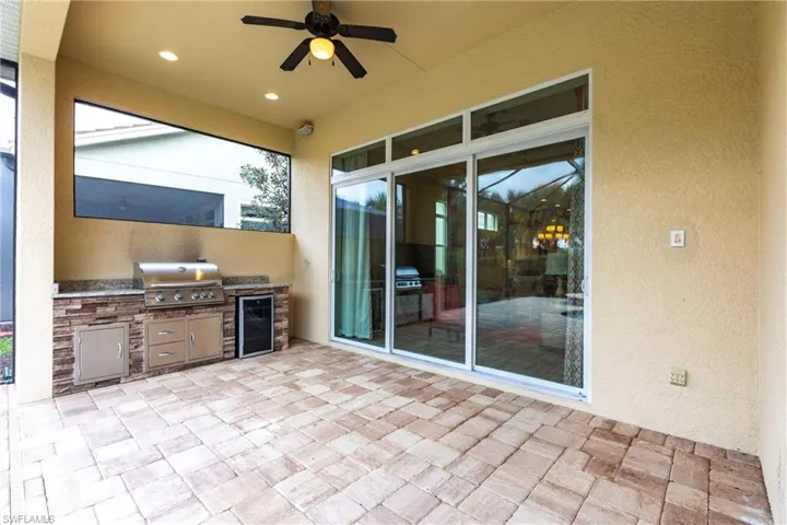 View of patio / lanai with ceiling fan, wine cooler, grilling area, and exterior kitchen