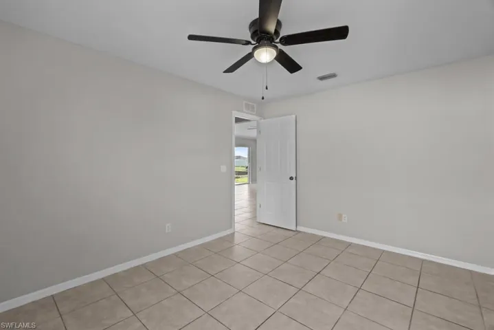 Unfurnished room with light tile patterned floors and ceiling fan