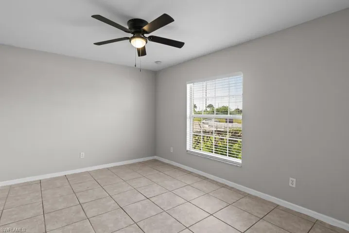 Spare room with light tile patterned floors and ceiling fan