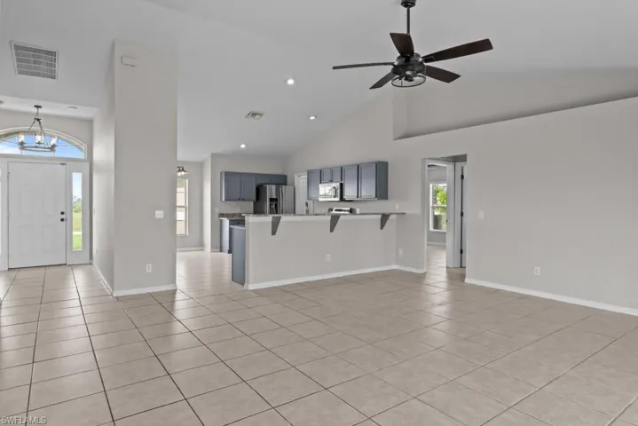 Unfurnished living room with high vaulted ceiling, light tile patterned floors, recessed lighting, and ceiling fan