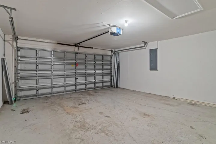 Garage with electric panel and a garage door opener