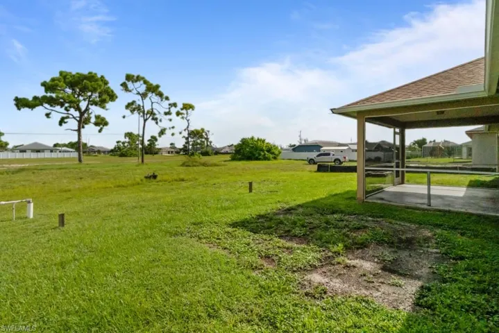 View of grassy yard with a sunroom
