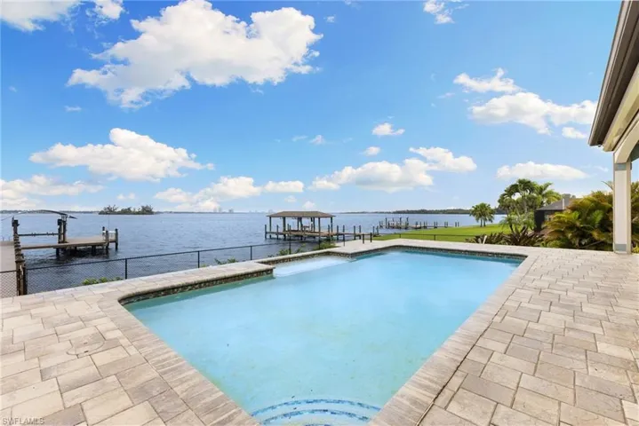 View of swimming pool featuring a water view and a dock