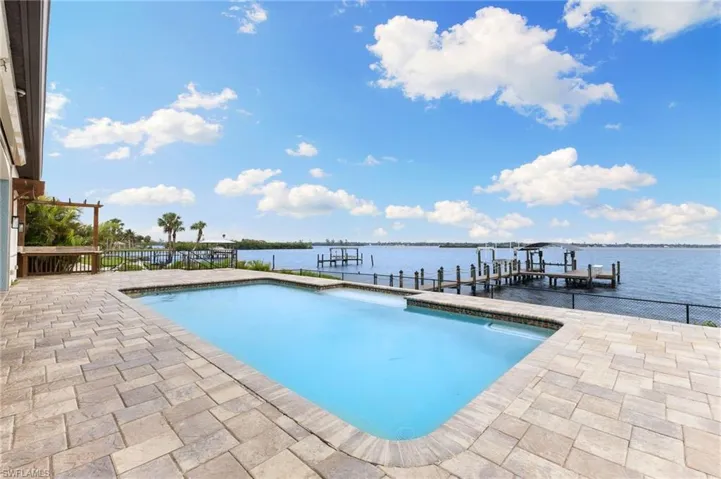 View of pool with a boat dock and a water view