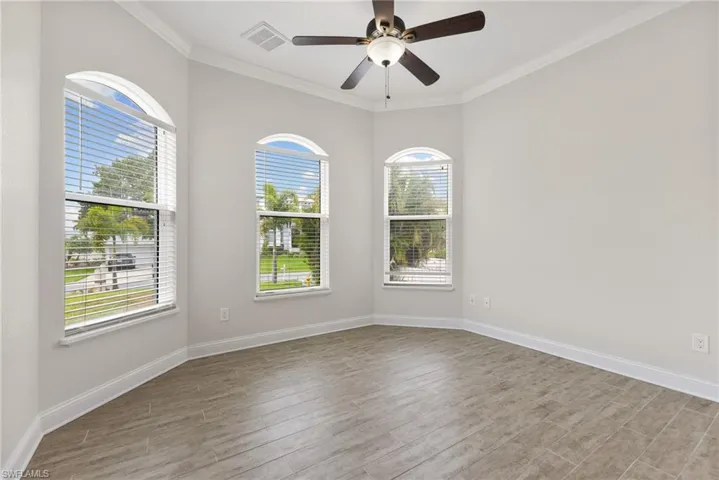 Unfurnished room with ceiling fan, light hardwood / wood-style flooring, and ornamental molding