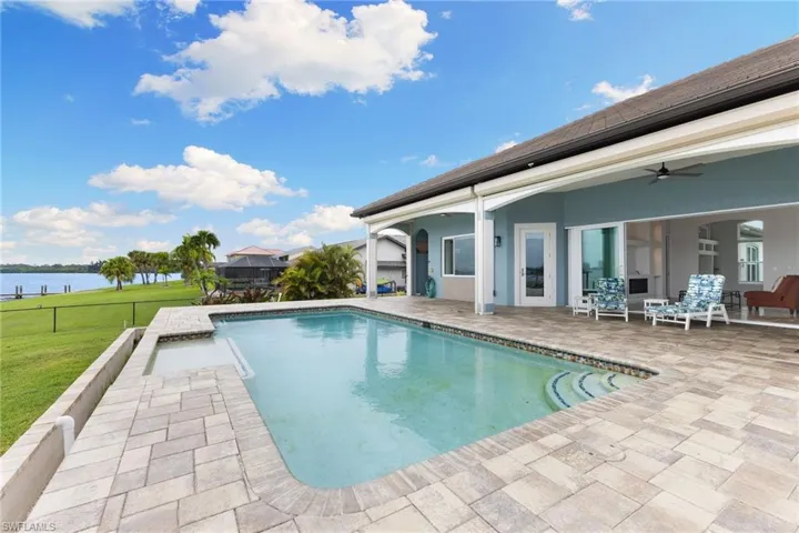 View of pool with a patio, ceiling fan, and a lawn