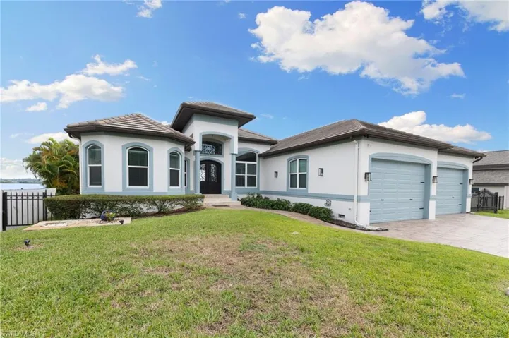 View of front of property featuring a front lawn and a garage