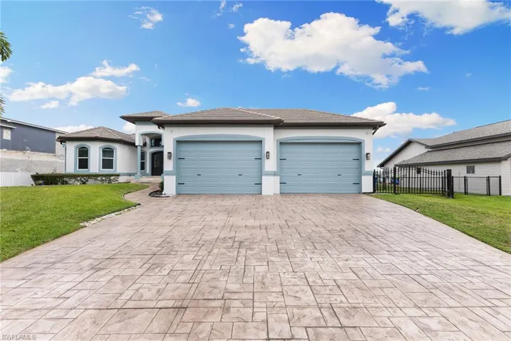 View of front of house featuring a garage and a front lawn