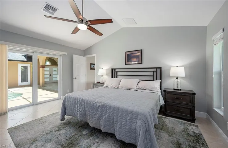 Tiled bedroom with access to exterior, ceiling fan, and lofted ceiling