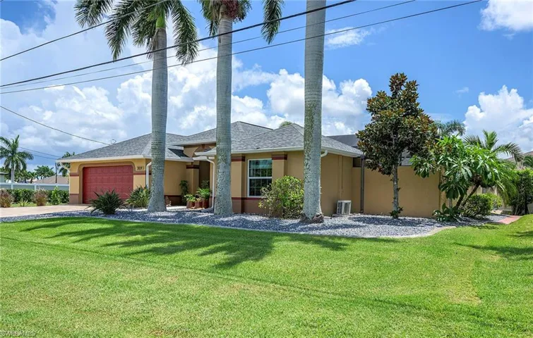 View of front facade featuring a garage, central AC unit, and a front yard