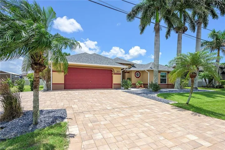 View of front of property featuring a garage and a front lawn