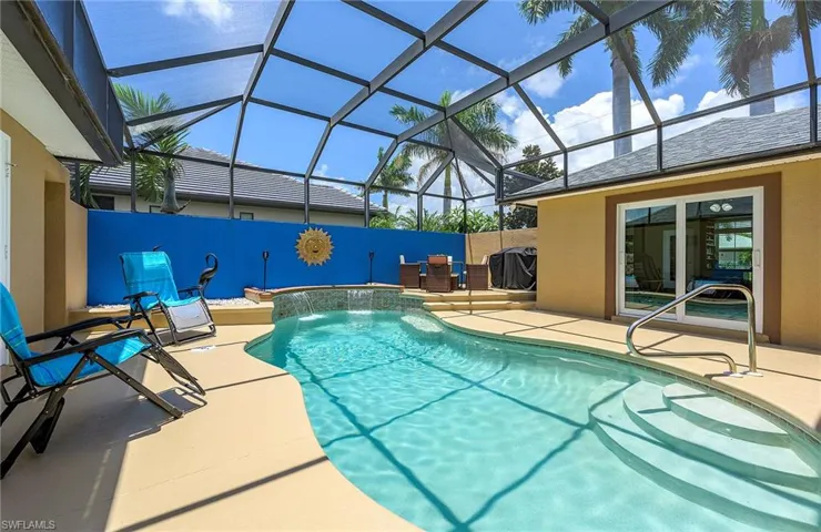 View of swimming pool with a patio, pool water feature, a grill, and glass enclosure