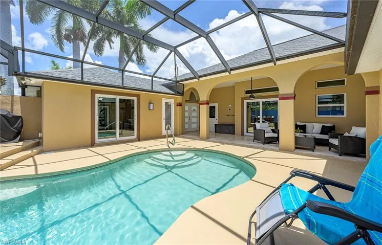 View of pool featuring an outdoor living space, a patio, a lanai, and grilling area