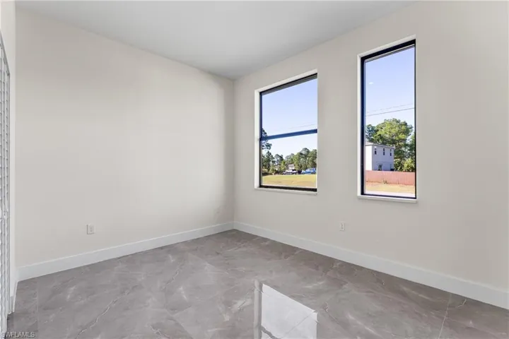 Unfurnished room with baseboards and light marble finish flooring