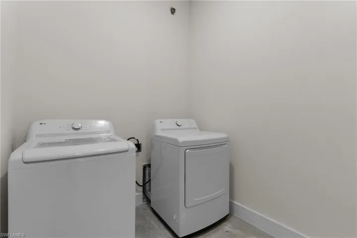 Washroom with baseboards and separate washer and dryer