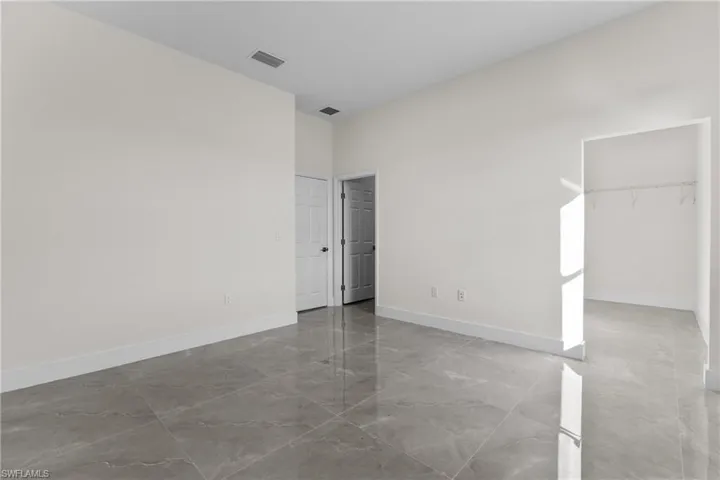 Unfurnished room with light marble finish floors