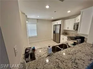 Kitchen featuring white cabinets, light stone countertops, appliances with stainless steel finishes, recessed lighting, and a peninsula