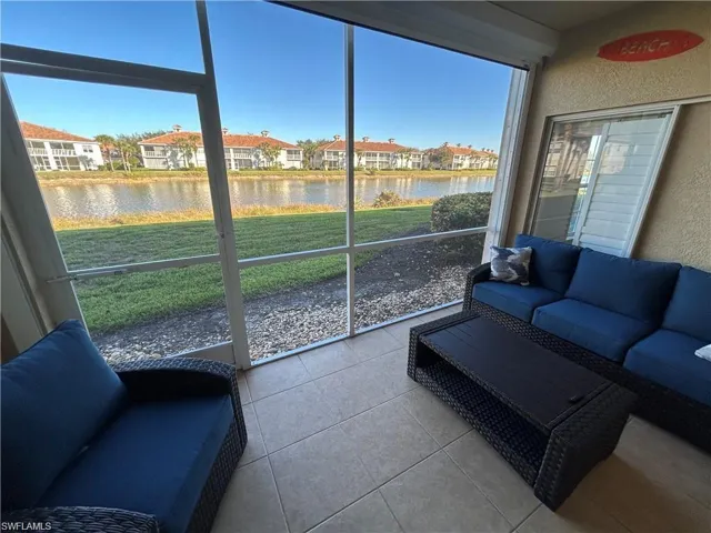 Sunroom / solarium featuring a water view, plenty of natural light, and a residential view