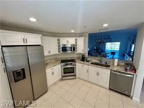 Kitchen with appliances with stainless steel finishes, white cabinetry, light countertops, light tile patterned floors, and recessed lighting