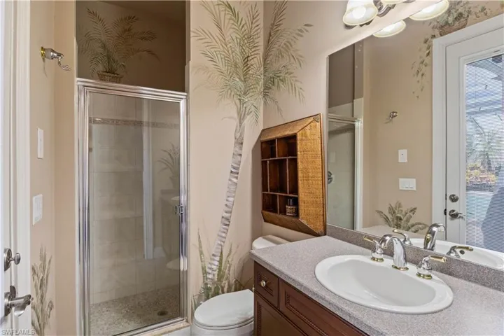 Bathroom with a shower with door, vanity, and toilet