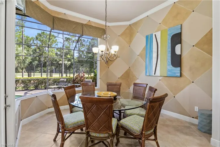 Dining area featuring crown molding, light tile patterned floors, and an inviting chandelier