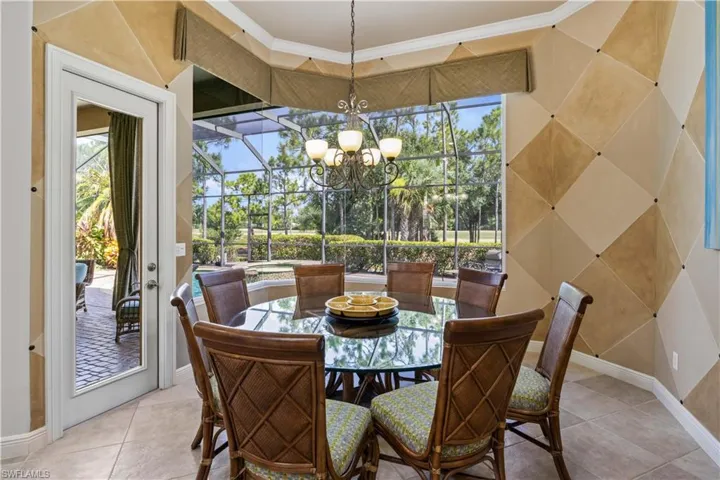 Tiled dining space with crown molding and a chandelier