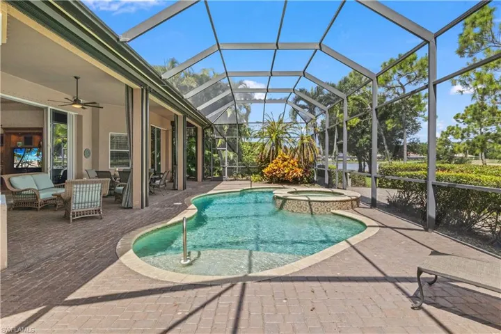 View of pool featuring an in ground hot tub, a lanai, outdoor lounge area, a patio, and ceiling fan