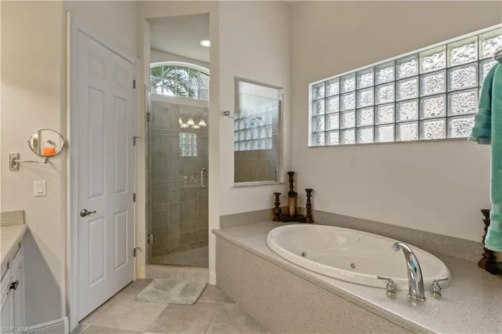 Bathroom with shower with separate bathtub, tile patterned floors, and vanity