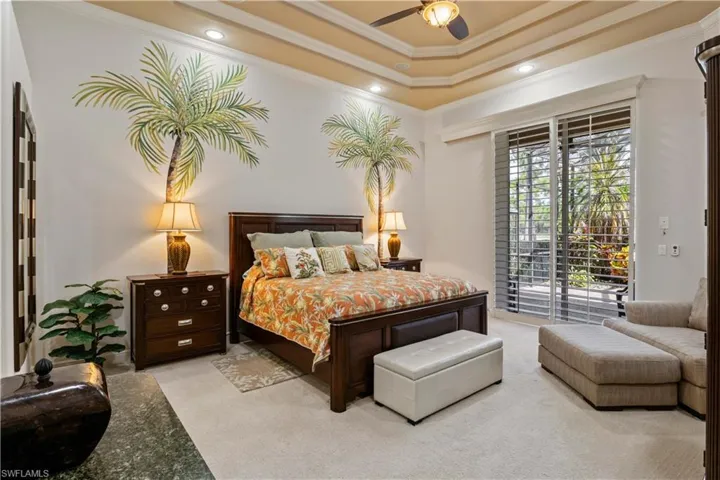 Carpeted bedroom featuring access to outside, ceiling fan, a raised ceiling, and crown molding