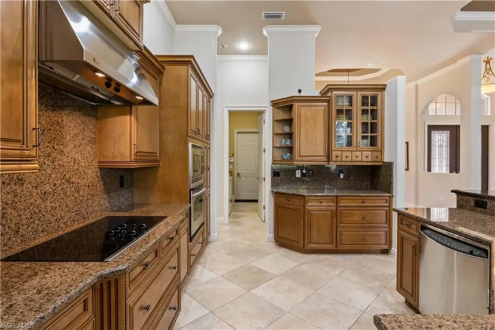 Kitchen featuring crown molding, tasteful backsplash, stainless steel appliances, and light tile patterned floors