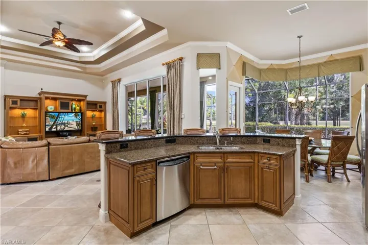 Kitchen with dark stone counters, dishwasher, plenty of natural light, and sink
