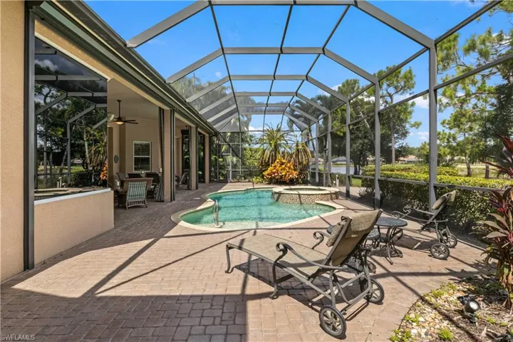View of swimming pool featuring an in ground hot tub, a patio, ceiling fan, and a lanai