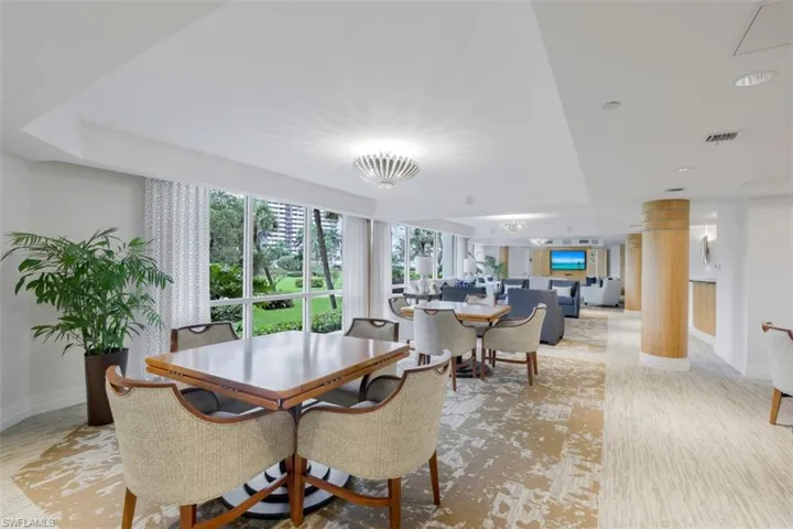 Social Room - dining space with light wood-type flooring and decorative columns