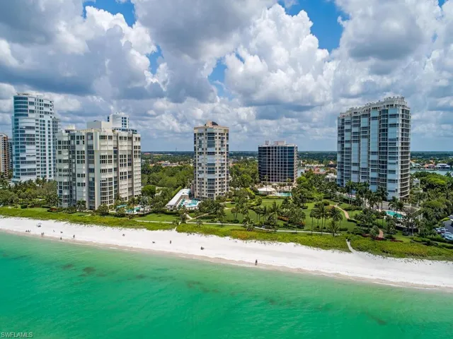 Birds eye view of property with a water view and a view of the beach