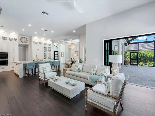 Living area with dark wood-style floors, ceiling fan, visible vents, and recessed lighting