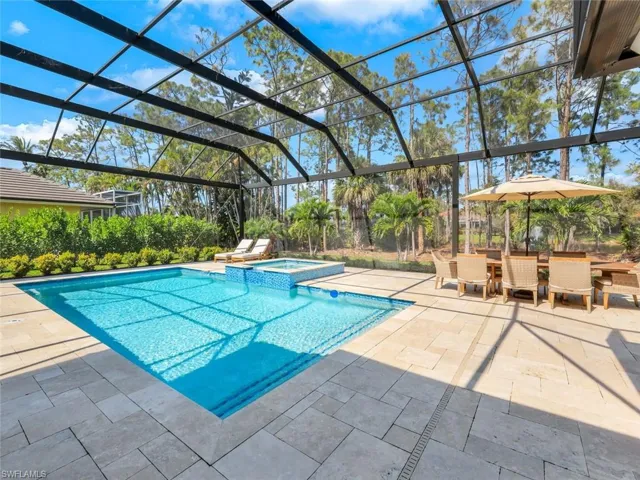 View of swimming pool with a lanai, a pool with connected hot tub, outdoor dining area, and a patio