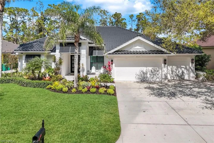 Single story home featuring a tile roof, stucco siding, concrete driveway, an attached garage, and a front lawn