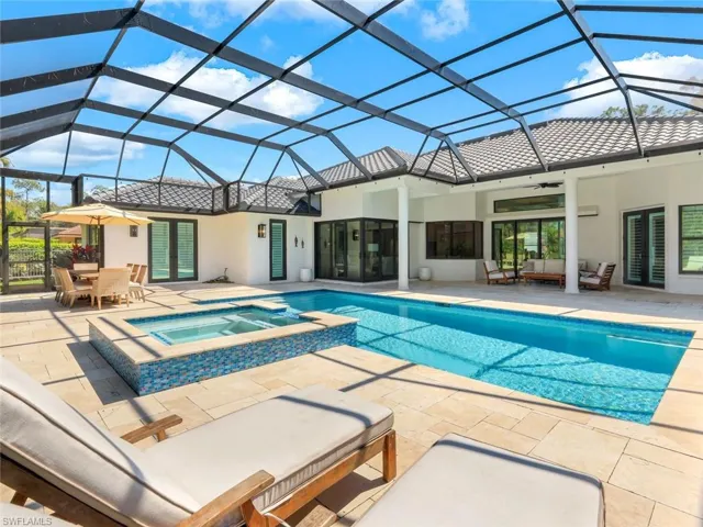 View of swimming pool with a patio, a pool with connected hot tub, an outdoor hangout area, a ceiling fan, and glass enclosure