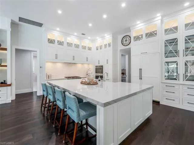 Kitchen featuring a spacious island, visible vents, white cabinetry, backsplash, and dark wood finished floors