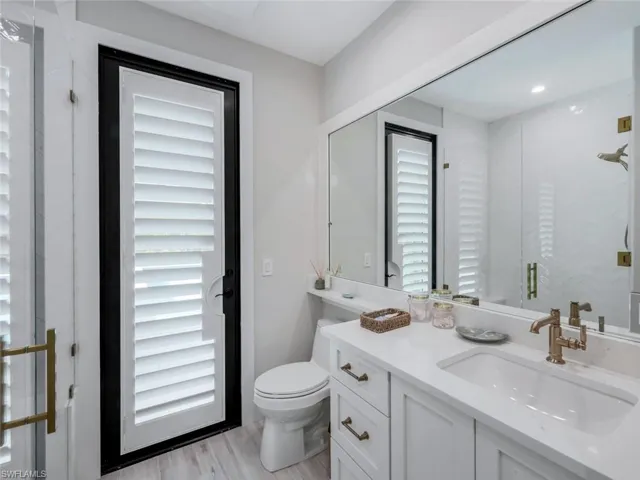 Bathroom with vanity, toilet, and wood finished floors