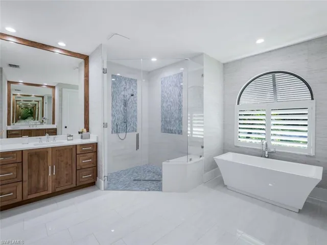 Bathroom with visible vents, a soaking tub, vanity, a shower stall, and recessed lighting