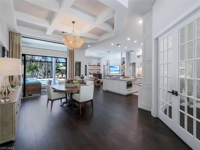 Dining room with a notable chandelier, recessed lighting, dark wood-type flooring, coffered ceiling, and beamed ceiling