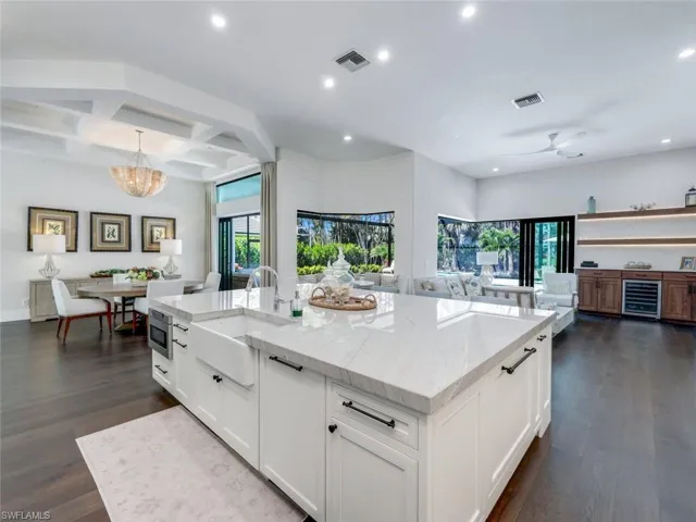 Kitchen with dark wood-style floors, open floor plan, visible vents, and a sink