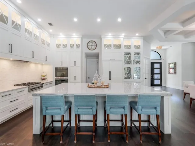 Kitchen with appliances with stainless steel finishes, white cabinets, visible vents, and tasteful backsplash