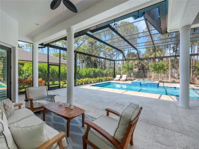 View of swimming pool featuring ceiling fan, a lanai, an outdoor hangout area, a pool with connected hot tub, and a patio area