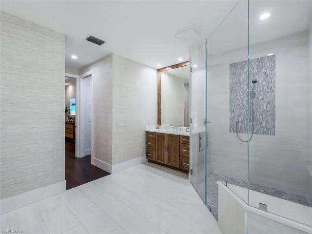 Bathroom featuring a stall shower, visible vents, baseboards, vanity, and recessed lighting