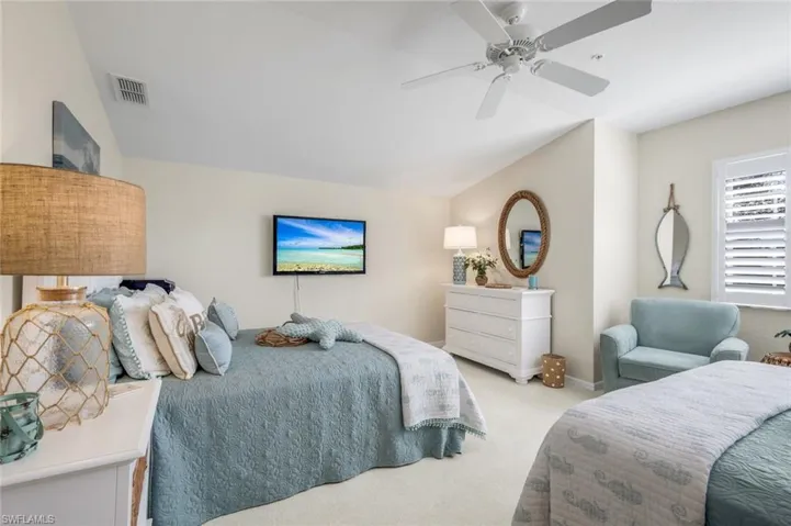 Bedroom featuring vaulted ceiling, carpet floors, and a ceiling fan