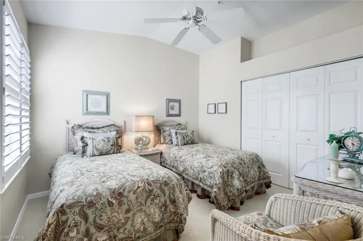 Bedroom with vaulted ceiling, carpet floors, a closet, and a ceiling fan