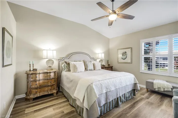 Bedroom with lofted ceiling, wood finished floors, and ceiling fan