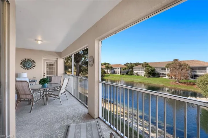 Balcony featuring a water view and outdoor dining space